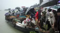 Orang-orang bersiap untuk turun dari kapal setelah dievakuasi dari daerah banjir menyusul hujan deras monsun di pinggiran Sylhet pada 17 Juni 2022. (Foto file: AFP)
