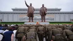 Tentara Rakyat Korea membungkuk di depan patung pemimpin Korea Utara, Kim Il Sung dan Kim Jong Il di Bukit Mansu, Pyongyang, pada peringatan 24 tahun kematian Kim Il Sung, Minggu (8/7). Kim Il-sung memimpin Korut sejak 1948 hingga 1994. (AFP/KIM Won-Jin)
