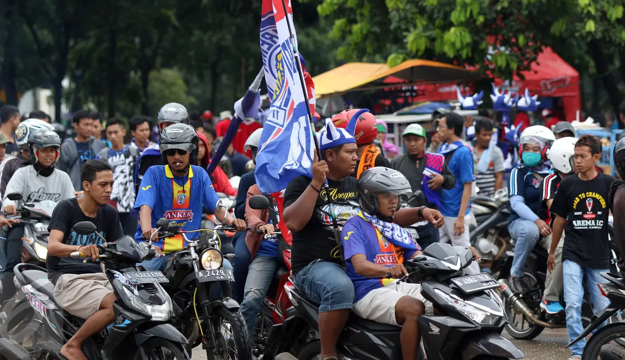 Suporter Arema FC membawa bendera menuju Stadion Pakansari, Kab Bogor untuk menyaksikan final Piala Presiden 2017, Sabtu (12/3). Di final, Arema FC dan PBFC akan berlaga memperebutkan gelar juara Piala Presiden 2017. (Liputan6.com/Helmi Fithriansyah)