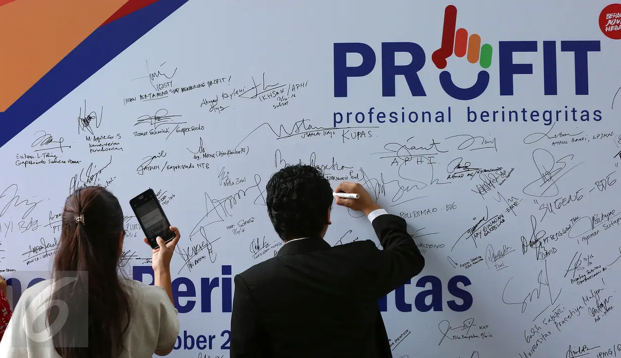 Pengunjung membubuhkan tanda tangan bentuk dukungan saat peluncuran logo PROFIT di Gedung baru KPK, Jakarta, Senin (17/10). PROFIT merupakan dukungan pengusaha swasta di dunia usaha untuk bekerjasama dengan KPK melawan korupsi. (Liputan6.com/JohanTallo)