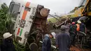 Petugas berusahan mengevakuasi kereta yang tergelincir di Asangaon, India (29/8). Sejauh ini tidak ada korban jiwa akibat kecelakaan kereta tersebut. (AP Photo / Rafiq Maqbool)
