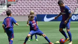 Gelandang baru Barcelona, Paulinho bermain bola dengan anak-anak saat perkenalan dirinya di Stadion Nou Camp, Barcelona, (17/8). Paulinho meneken kontrak empat musim di Camp Nou. (AFP Photo/Lluis Gene)