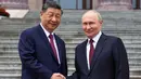 Presiden Rusia Vladimir Putin (kanan) dan Presiden China Xi Jinping berjabat tangan saat upacara penyambutan di Balai Besar Rakyat, Beijing, China, pada Rabu 20 Mei 2026. (Alexander Kazakov, Sputnik, Kremlin Pool Photo via AP)