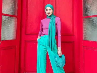 Tampil dengan busana berwarna serba tosca, Donita memilih untuk memadukannya dengan sebuah turtle neck berwarna ungu. Gaya hijab yang sederhana serta tas yang unik ini tak lepas dari perhatian netizen. (Liputan6.com/IG/@donitabhubiy)