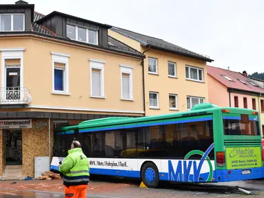 Bus sekolah terparkir di depan bangunan setelah menabrak tembok sebuah toko di Eberbach dekat Mannheim, Jerman, Selasa (16/1). Setidaknya 48 orang terluka dalam kecelakaan bus yang membawa anak-anak sekolah tersebut. (Uwe Anspach/dpa via AP)