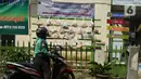 Pengemudi ojek online mengambil sembako yang digantung di rak kayu di kawasan Rawa Barat, Jakarta Selatan, Kamis (14/5/2020). Selama masa pandemi COVID-19, pihak kelurahan dan masjid sekitar menyediakan paket berisi mi instan, telur, dan masker untuk warga yang membutuhan. (merdeka.com/Imam Buhori)