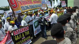 Karyawan Merpati melangsungkan demonstrasi damai sambil membawa poster dan memakai ikat kepala berwarna kuning berisi tentang tuntutan, Jakarta, (16/8/14). (Liputan6.com/Miftahul Hayat)
