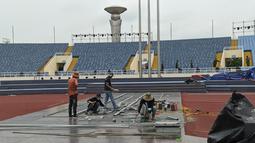 Para pekerja berlomba dengan waktu untuk menyelesaikan bagian-bagian stadion yang perlu dipermak. (Bola.com/Muhammad Adiyaksa)