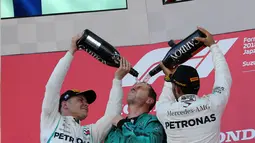 Pembalap Mercedes, Lewis Hamilton (kanan) merayakan kemenangannya di Formula Satu (F1) Grand Pix Jepang di Sirkuit Suzuka, Jepang (7/10). Hamilton berhasil mengalahkan rekan setimnya, Valtteri Bottas yang menempati posisi kedua. (AP Photo/Toru Takahashi)