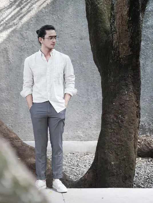 Pria kelahiran 1995 ini tampan dan gagah dengan outfit semiformalnya. Omar memakai celana bahan berwana abu-abu dan kemeja putih, meski yang dimasukan hanya satu sisi saja. Rambutnya juga terlihat begitu rapi dengan dikuncir. (Instagram/omardaniel_)