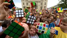 Murid-murid Hungaria berpose dengan Kubus Rubik usai melakukan flashmob di Budapest pada 12 Juni 2024. (Ferenc ISZA/AFP)