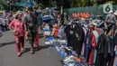 Warga melintasi pedagang kaki lima (PKL) yang berjualan di kawasan Jalan Sumenep, Jakarta, Minggu (17/11/2019). Jalan Sumenep dan Jalan Pamekasan merupakan titik yang sudah ditentukan untuk berjualan saat car free day (CFD). (Liputan6.com/Faizal Fanani)
