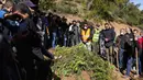 Orang-orang berdiri di samping makam Rayan Oram (5) saat pemakamannya di Desa Ighran, Provinsi Chefchaouen, Maroko, 7 Februari 2022. Rayan Oram meninggal setelah terjebak selama lima hari dalam sumur kering sedalam 32 meter. (AP Photo/Mosa'ab Elshamy)