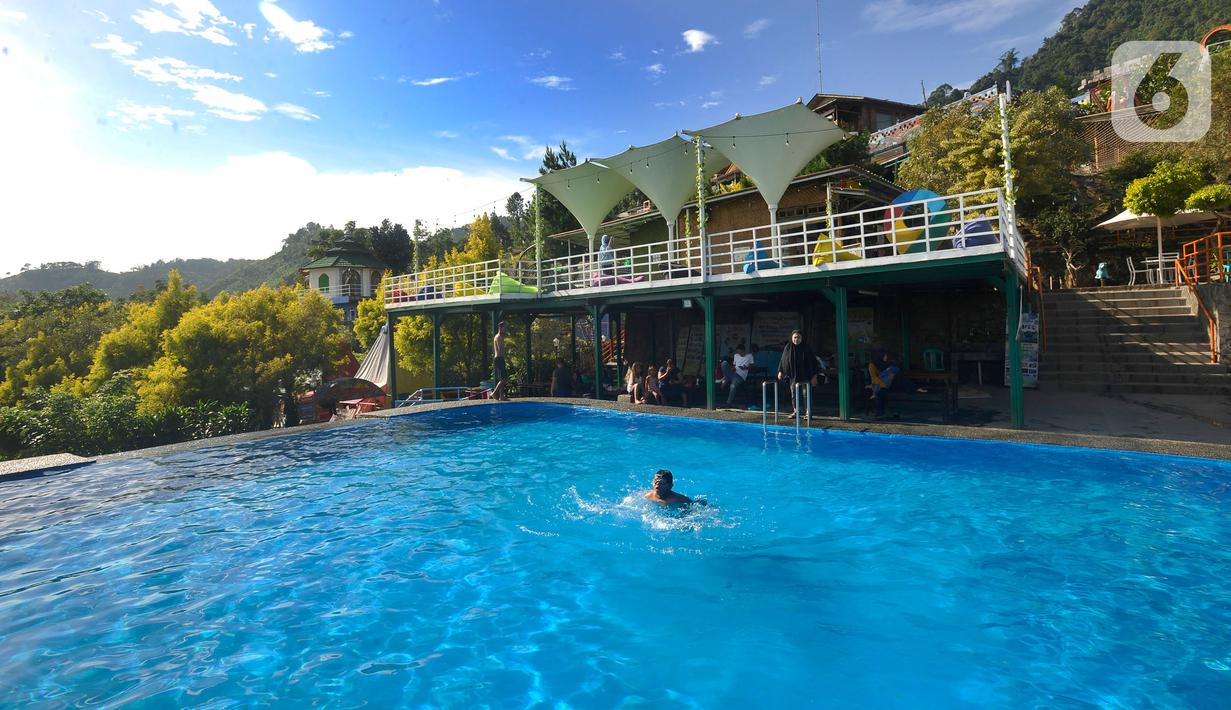 Wisatawan berenang saat mengunjungi tempat wisata yang Instagrammable di kawasan Puncak Dua, Sukamakmur, Bogor, Jumat (6/1/2023). Meski kawasan Puncak Dua belum dikembangkan secara maksimal oleh Pemkab Bogor dan pemerintah pusat, warga seputar Jabodetabek dan Cianjur tetap antusias mengunjungi kawasan ini sebagai tempat wisata alternatif selain kawasan Puncak dan sekitarnya yang selalu didominasi kemacetan lalu lintas. (merdeka.com/Arie Basuki)
