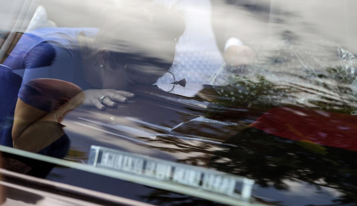 Seorang pelayat mencium peti dari jenazah pesepak bola Nantes, Emiliano Sala, saat tiba di Club Atletico, Santa Fe, Sabtu (16/2). Emiliano Sala meninggal dunia setelah kecelakaan pesawat. (AFP/Juan Mabromata)