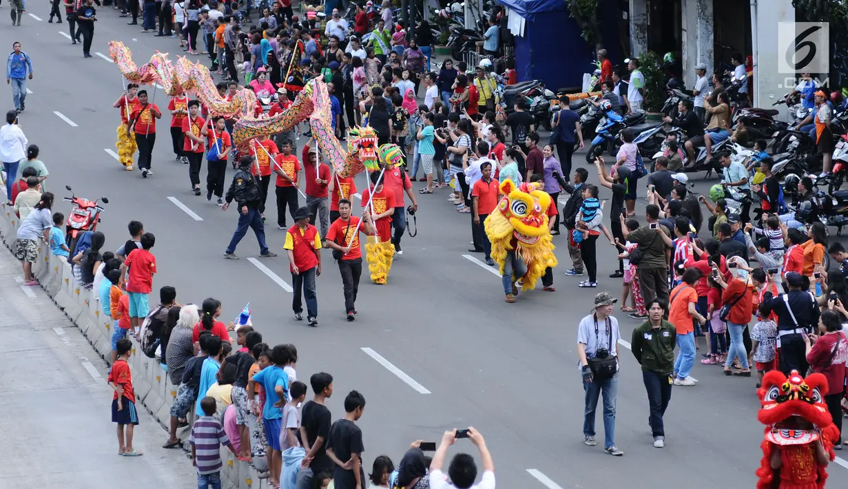 Warga menyaksikan iring-iringan liong di ruas Jalan Gajah Mada, Jakarta saat karnaval Cap Go Meh 2018, Minggu (4/3). Beragam atraksi budaya ditampilkan pada karnaval Cap Go Meh 2018 di kawasan Glodok Jakarta. (Liputan6.com/Helmi Fithriansyah)