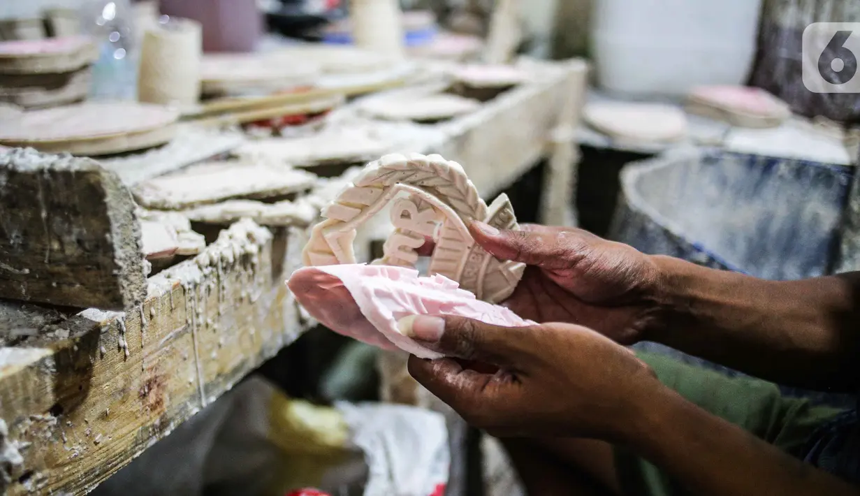 Pekerja mengeluarkan plakat dari cetakan saat proses pembuatan di Industri Rumahan Pluit, Penjaringan, Jakarta Utara, Rabu (30/10/2019). Plakat yang terbuat dari bahan baku resin plastik tersebut didistribusikan di kawasan Ibu Kota. (Liputan6.com/Faizal Fanani)