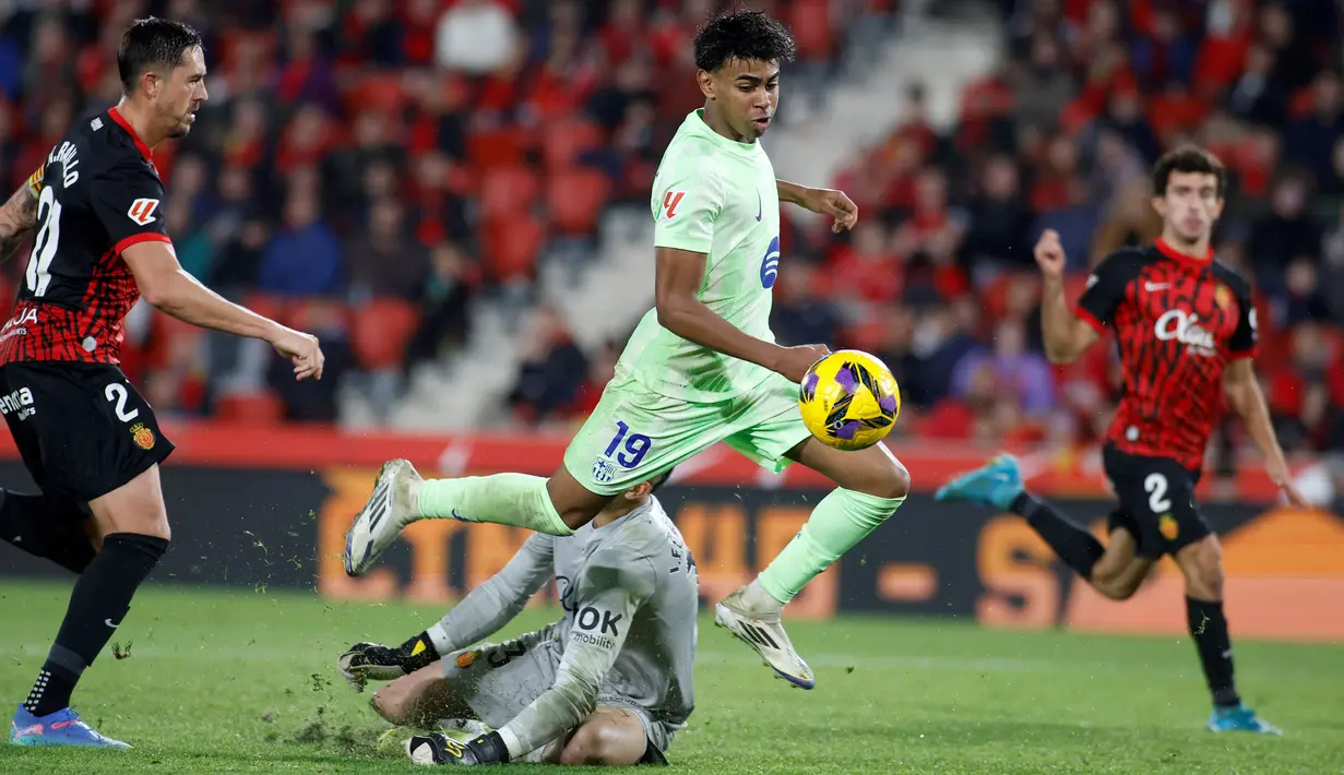 Pemain Barcelona, Lamine Yamal berusaha melewati kiper Mallorca, Leo Roman pada laga lanjutan Liga Spanyol 2024/2025 di Stadion Mallorca Son Moix, Mallorca, Spanyol, Rabu (04/12/2024) dini hari WIB. (AFP/Jaime Reina)