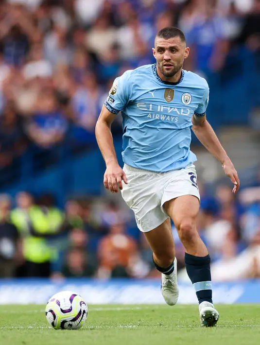 Pemain Manchester City, Mateo Kovacic menggiring bola pada laga Liga Inggris 2024/2025 melawan Chelsea di Stamford Bridge, London, Inggris, Minggu (18/08/2024) malam WIB. (AFP/Adrian Dennis)