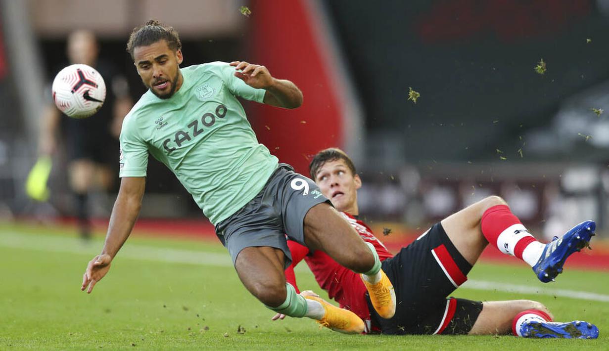 Pemain Everton, Dominic Calvert-Lewin, terjatuh saat berebut bola dengan pemain Southampton, Jannik Vestergaard, pada laga Liga Inggris di Stadion St. Mary's Minggu (25/10/2020). Southampton menang dengan skor 2-0. (Naomi Baker/Pool via AP)