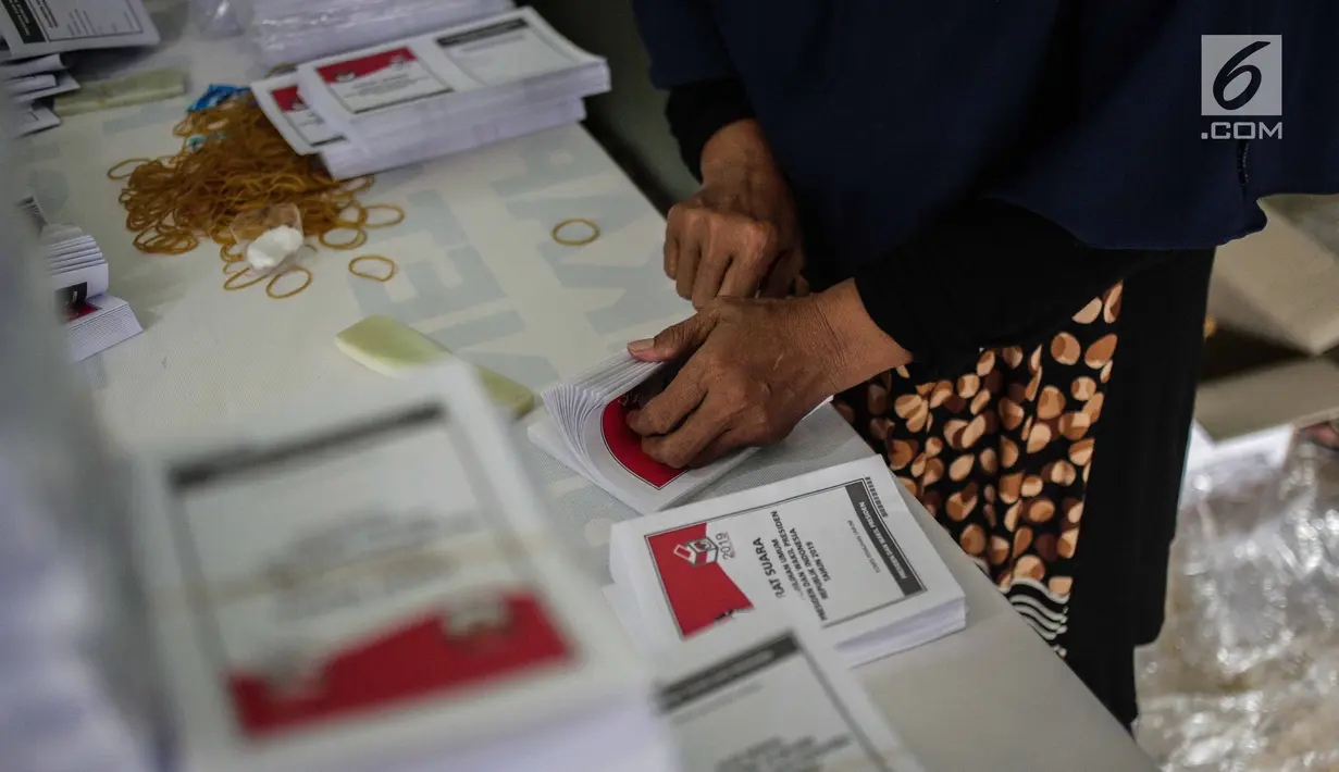 Seorang pekerja menyelesaikan pelipatan surat suara Pemilihan Umum 2019 di gudang logistik KPU Jakarta Pusat, Selasa (19/2). Proses pelipatan surat suara diiikuti 62 orang yang direkrut dari wilayah sekitar gudang KPU. (Liputan6.com/Faizal Fanani)