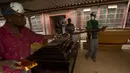 Sphiwe Maseko (kanan) memindahkan peti mati di bengkelnya, Evaton, selatan Johannesburg, Afrika Selatan, Senin (15/2/2021). Maseko mengatakan, bahan dan biaya pembuatan peti mati telah naik karena pemasok yang lebih sedikit dampak pandemi COVID-19. (AP Photo/Themba Hadebe)