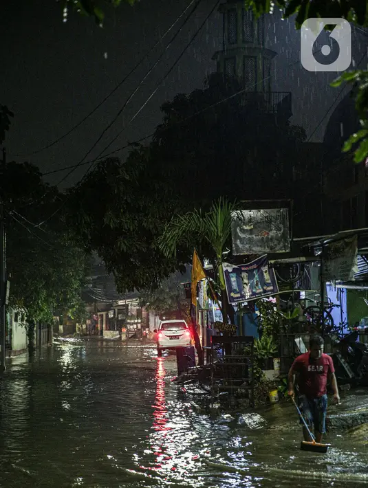 Warga membersihkan depan rumah yang tergenang banjir di kawasan Mampang Prapatan, Jakarta, Sabtu (13/11/2021). Intensitas hujan yang tinggi sejak sore di Jakarta membuat kawasan permukiman di Mampang Prapatan tergenang banjir dengan tinggi sebetis orang dewasa. (Liputan6.com/Faizal Fanani)