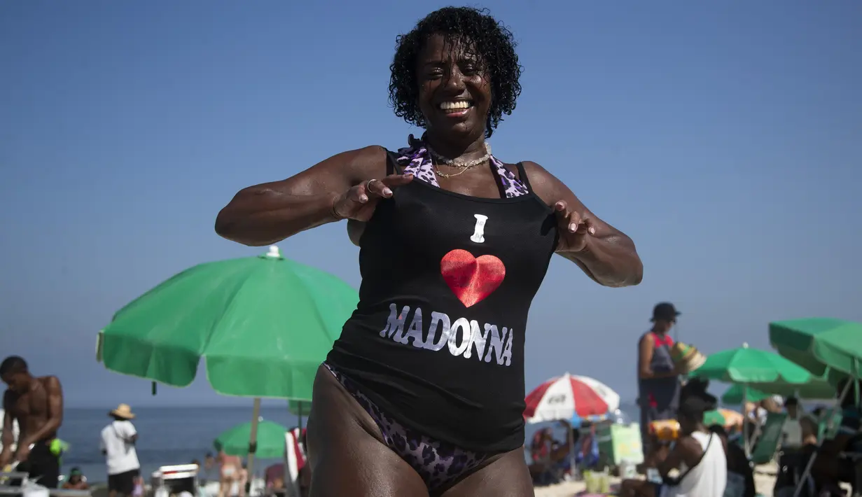 Pengunjung pantai Elizabeth Goncalves memamerkan kaus Madonna yang baru dibelinya menjelang konser Madonna di pantai Copacabana di Rio de Janeiro, Brasil, Senin (29/4/2024). (AP Photo/Bruna Prado)