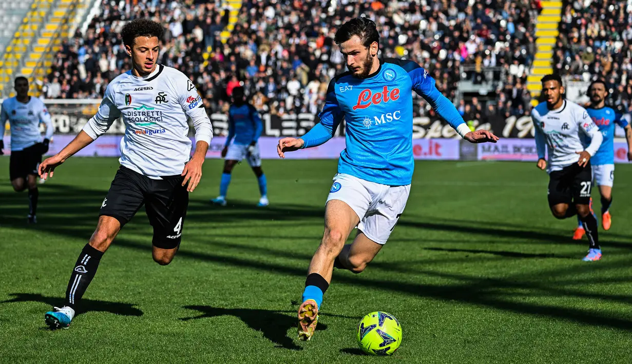 Pemain Napoli, Khvicha Kvaratskhelia (kanan) berebut bola dengan pemain Spezia, Ethan Ampadu pada laga lanjutan Liga Italia 2022/2023 di Alberto-Picco Stadium, Spezia, 5 Februari 2023. Mahar Kvaratskhelia dianggap dapat mencapai 100 juta euro. Arsenal, MU, sampai PSG disebutkan tertarik mendatangkan sang pemain di bursa transfer musim depan. (AFP/Alberto Pizzoli)