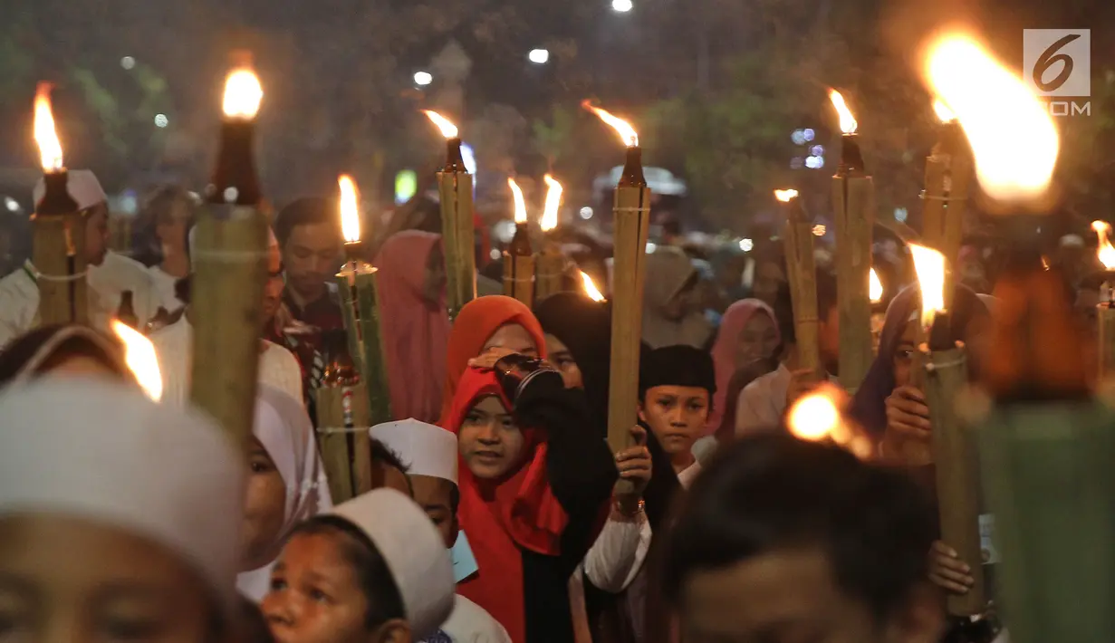 Anak-anak mengikuti pawai obor di kawasan Mampang Prapatan, Jakarta, Sabtu (12/5). Pawai obor berkeliling dari Pejatan sampai Warung Buncit menyambut Ramadan 1439 H. (Liputan6.com/Herman Zakharia)