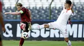 bola dengan bek Montenegro Marko Vesovic dalam duel uji coba internasional jelang Euro 2024 di Stade Roi Baudouin, Brussels, Kamis (6/6/2024). (Kenzo TRIBOUILLARD / Belga / AFP)