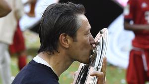 Pelatih Bayern Munchen, Niko Kovac, mencium trofi Bundesliga usai mengalahkan Frankfurt di Allianz Arena, Jerman, Sabtu (18/5). Munchen menang 5-1 atas Frankfurt. (John Macdougall/AFP)