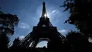 Matahari bersinar di antara struktur Menara Eiffel, Paris, Kamis (2/8). Perubahan tiket membuat  antrean turis begitu panjang, staf pun protes dan mogok kerja sehingga Eiffel terpaksa ditutup. (AFP PHOTO/GERARD JULIEN)