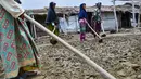Para petani tradisional menyiapkan lahan untuk pengolahan air laut yang menjadi bahan baku utama pembuatan garam di Lampanah, Aceh Besar, Aceh, Senin (26/8/2019). Setiap petani di permukiman Lampanah mampu memproduksi garam sekitar 150 - 200 kilogram per hari yang dijual Rp5.000 per kilogram. (CHAID