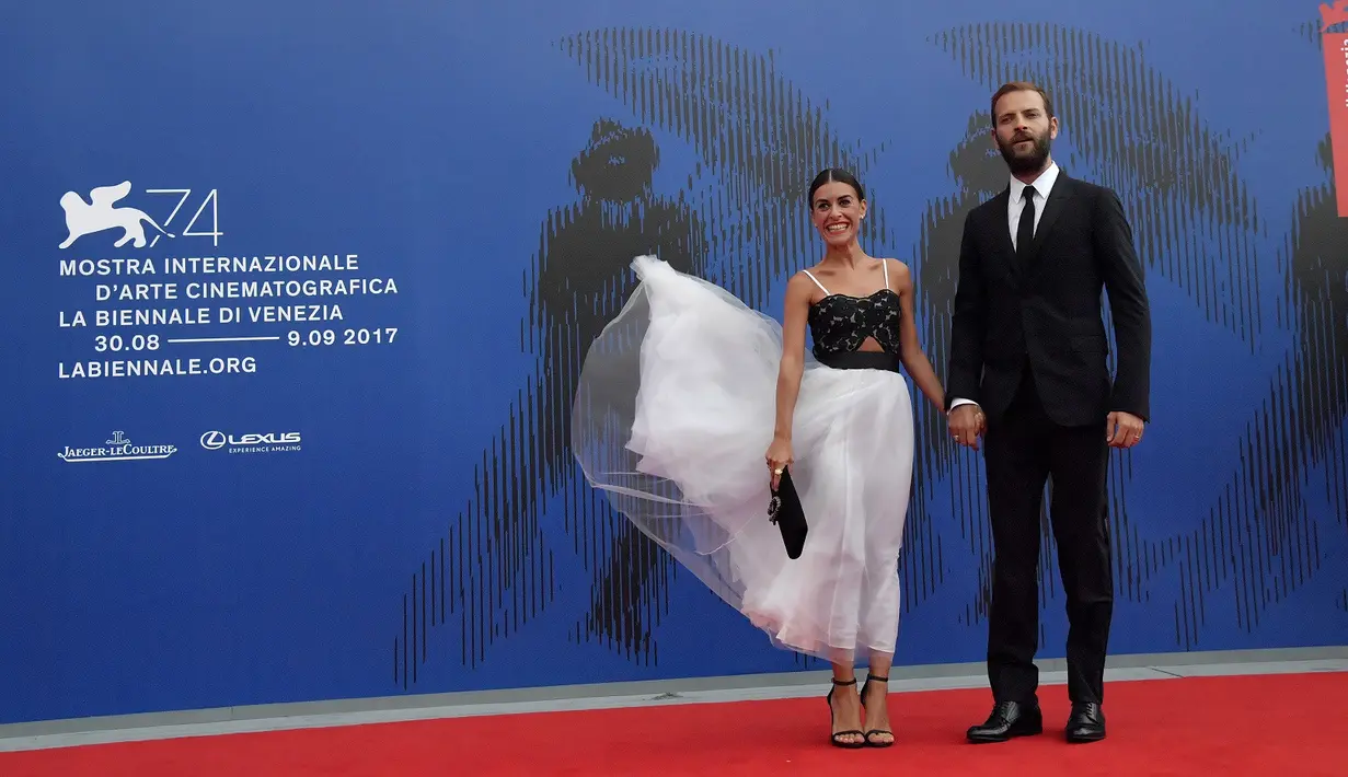 Gaun Aktris Roberta Pitrone (kiri)  tertiup angin saat menghadiri "Penghargaan Franca Sozzani" selama Festival Film Venice ke-74 di Venice Lido (1/9). (AFP Photo/Tizianaa Fabi)