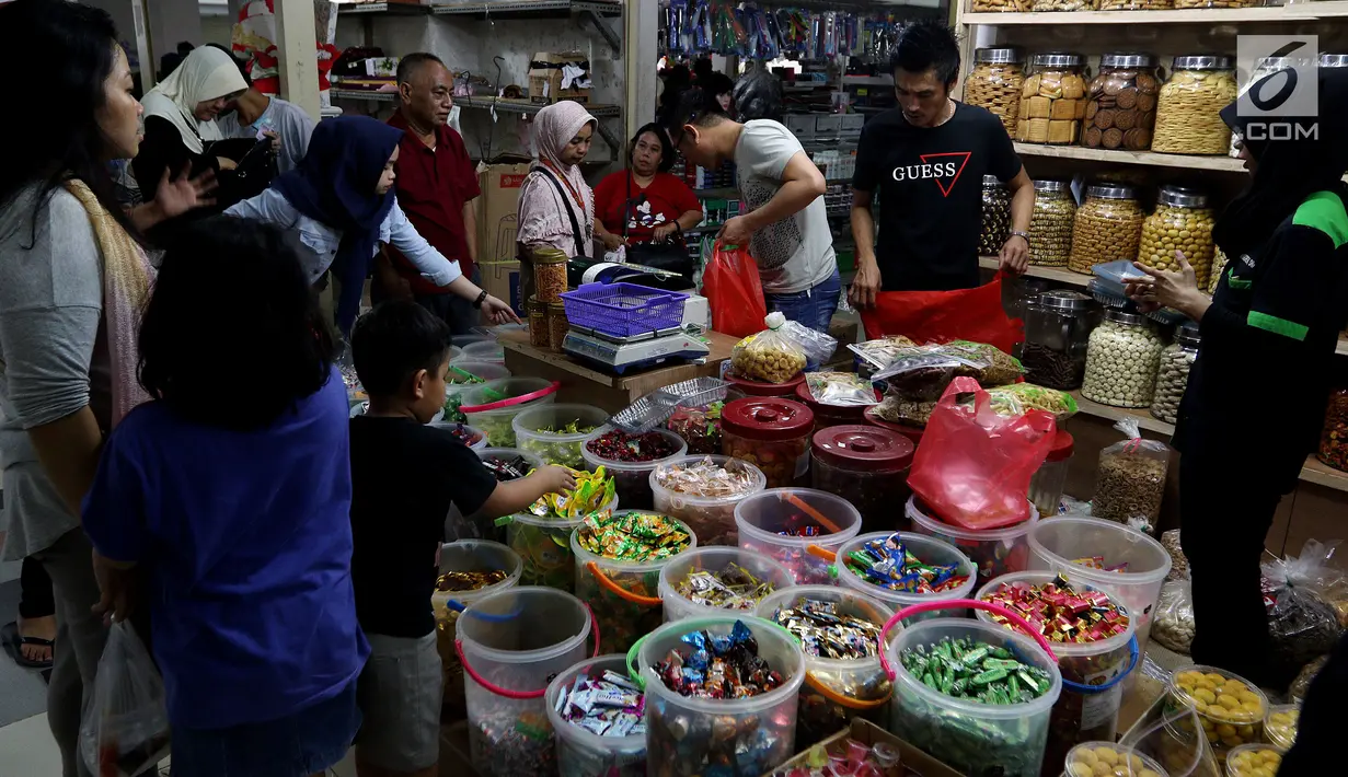 Sejumlah pembeli memilih kue kering di Pasar Mayestik, Jakarta Selatan, Senin (11/6). Separuh Ramadan dan jelang lebaran masyarakat mulai berburu kue kering. (Liputan6.com/Johan Tallo)