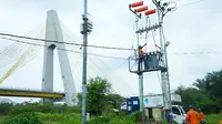 Petugas PLN Riau tengah memasang instalasi listrik. (Liputan6.com/Dok PLN Riau/M Syukur)