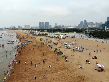 Foto yang diabadikan dari udara pada 9 Juli 2020 ini memperlihatkan orang-orang yang sedang menikmati waktu bersantai di sebuah pantai di Rizhao, Provinsi Shandong, China timur. (Xinhua/Wang Kai)