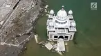 Pandangan udara Masjid Terapung Arqam Bab Al Rahman pasca gempa dan tsunami Palu di Pantai Talise, Sulawesi Tengah. Bangunan masjid yang terletak di pinggir pantai terlihat utuh meski sebagian bangunannya tenggelam. (Liputan6.com/Fery Padolo)