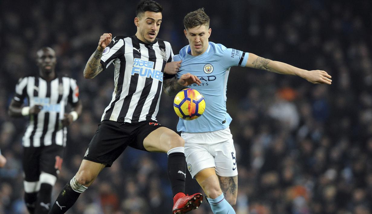 Duel pemain Newcastle, Joselu (kiri) dan pemain Manchester City, John Stones pada laga Premier League di Etihad Stadium, Manchester, (20/1/2018). Manchester City menang 3-1. (AP/Rui Vieira)