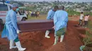 Petugas yang mengenakan pakaian pelindung menurunkan peti mati seorang anak berusia enam tahun yang meninggal akibat Ebola saat pemakaman di Bunia, Provinsi Ituri, Kongo timur, Selasa, 18 Agustus 2026. (Foto AP/Dieudonne Dirole)