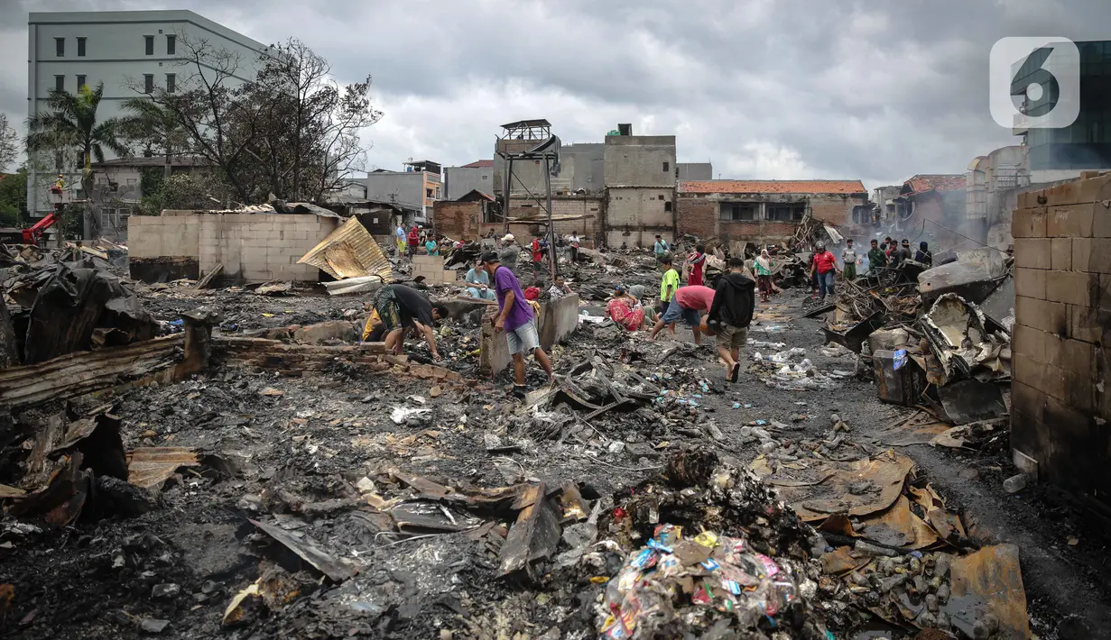 Warga mencari barang berharga di sekitar puing-puing bangunan tempat tinggal mereka yang terbakar di Jalan Tanah Abang 5 RT 003,004/RW 003, Petojo Selatan, Gambir, Jakarta Pusat, Senin (27/2/2023). Api selesai dipadamkan pada Senin (27/2/2023) pukul 01.18 WIB. Sementara itu, penyebab kebakaran masih dalam proses pendataan. (Liputan6.com/Faizal Fanani)
