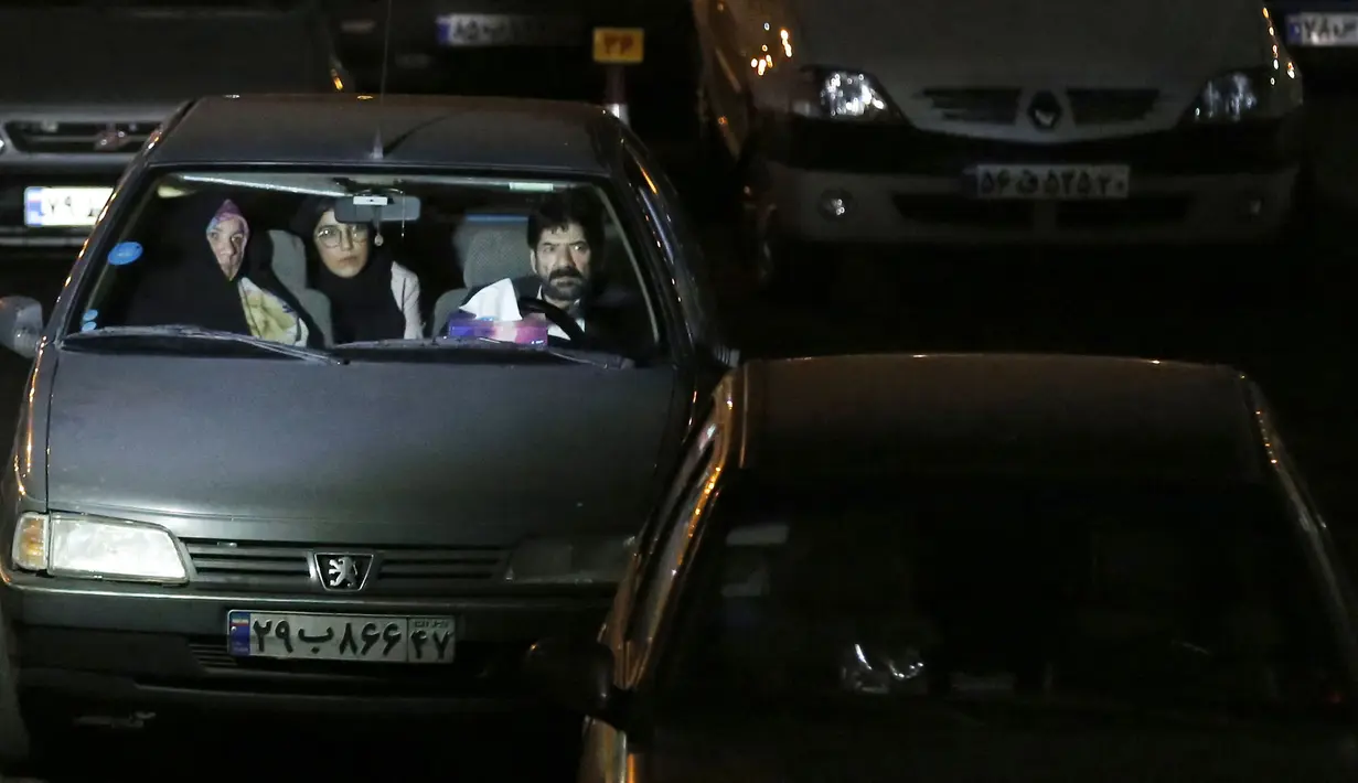 Warga duduk dalam mobil saat upacara keagamaan pada bulan suci Ramadan di tengah pandemi COVID-19, Teheran, Iran, Kamis (30/4/2020). Keluarga-keluarga di Iran menghadiri upacara keagamaan drive-in karena tidak memiliki kesempatan untuk salat di masjid setelah berbuka puasa. (STR/AFP)