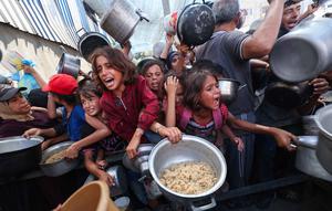 Sedikitnya, 650.000 anak menghadapi kelaparan akut dan 22.000 pasien yang membutuhkan perawatan terjebak di Gaza akibat kekurangan pasokan obat-obatan, bahan bakar, dan makanan. Tampak dalam foto, anak-anak Palestina berdesak-desakan untuk mendapatkan makanan hangat dari dapur amal di kamp pengungsi Nuseirat di Jalur Gaza yang dikepung Israel pada 4 September 2025. (Eyad BABA/AFP)