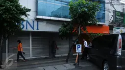 Sejumlah orang berdiri di depan perkantoran yang ditutup di Jalan Agus Salim Jakarta, Kamis (14/1). Pasca ledakan di pos polisi dekat Gedung Sarinah, sejumlah toko dan kantor di sekitar lokasi menghentikan aktivitasnya. (Liputan6.com/Helmi Fithriansyah)