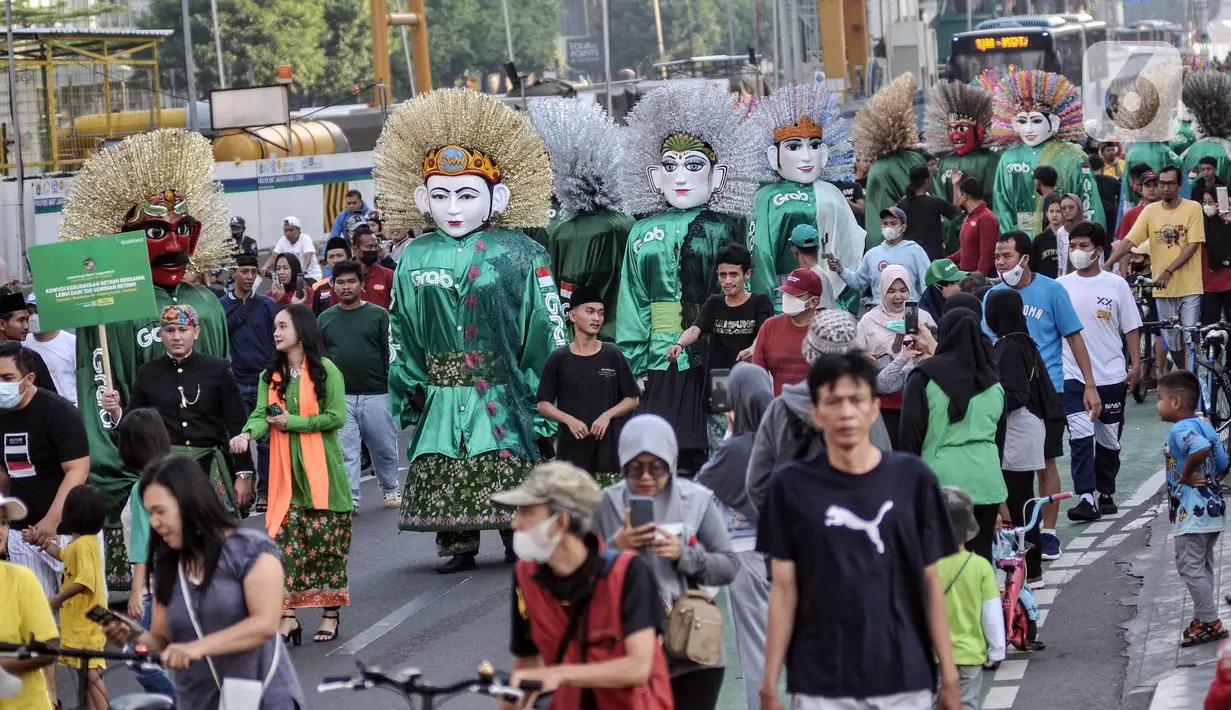 Ondel-ondel tampil dalam pawai budaya dan kesenian Betawi saat Hari Bebas Kendaraan Bermotor (HBKB) atau car free day (CFD) di Jalan MH Thamrin, Jakarta, Minggu (19/6/2022). Pawai yang menampilkan berbagai budaya dan kesenian Betawi seperti ondel-ondel, tari topeng, serta tanjidor tersebut digelar dalam rangka menyambut HUT ke-495 DKI Jakarta. (merdeka.com/Iqbal S. Nugroho)