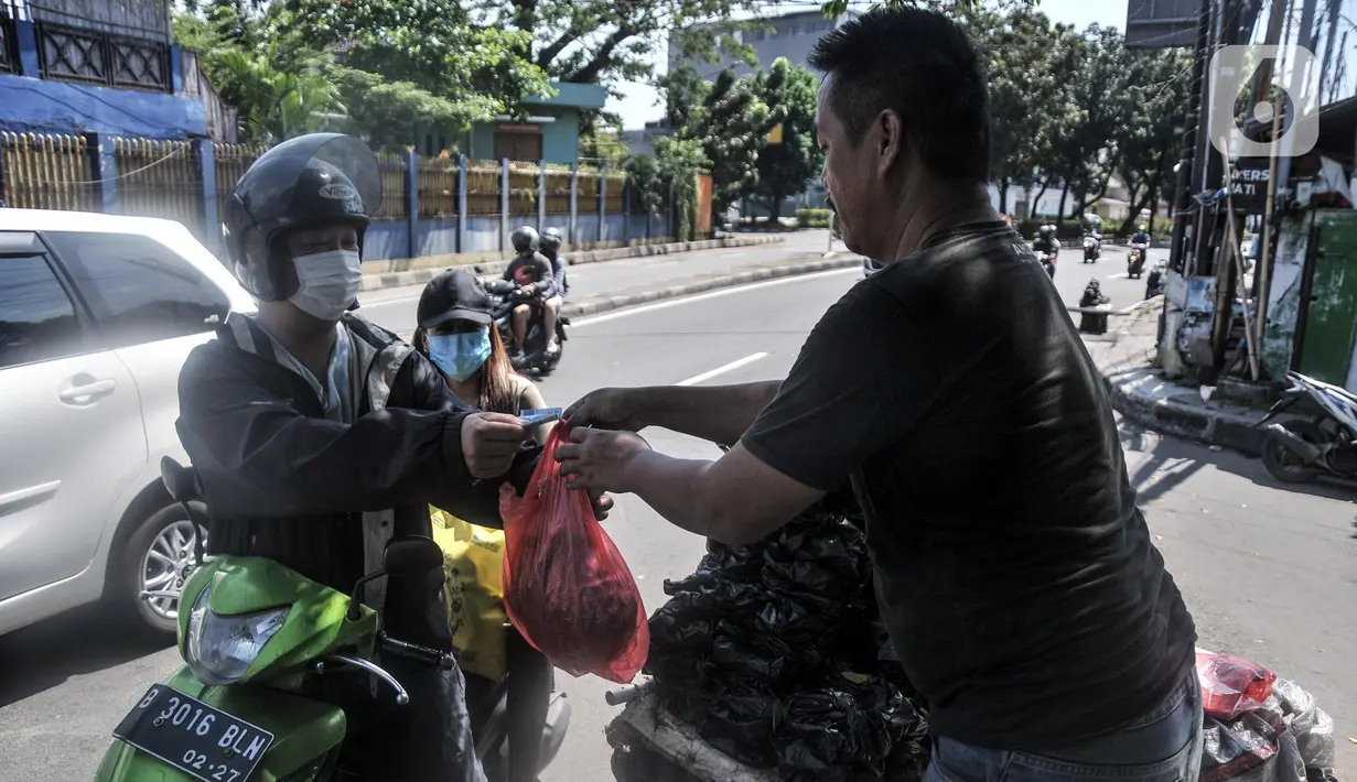 Pedagang arang melayani pembeli di kawasan Manggarai, Jakarta Selatan, Minggu (10/7/2022). Harga arang di tempat ini relatif murah mulai dari Rp 5.000 hingga Rp 25.000 per bungkus. (merdeka.com/Iqbal S. Nugroho)