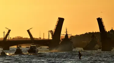 Kapal perang Rusia berlayar di sungai Neva melalui jembatan gantung selama latihan parade Angkatan Laut di Saint Petersburg pada awal 16 Juli 2023. (AFP/Olga Maltseva)