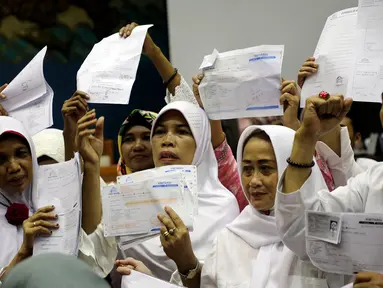 Calon jemaah umrah First Travel menunjukkan kwitansi saat mendatangi gedung DPR bertemu dan mengadu ke Komisi VIII DPR Fraksi PPP, di Kompleks Parlemen, Senayan, Jakarta, Jumat (18/8). (Liputan6.com/Johan Tallo)