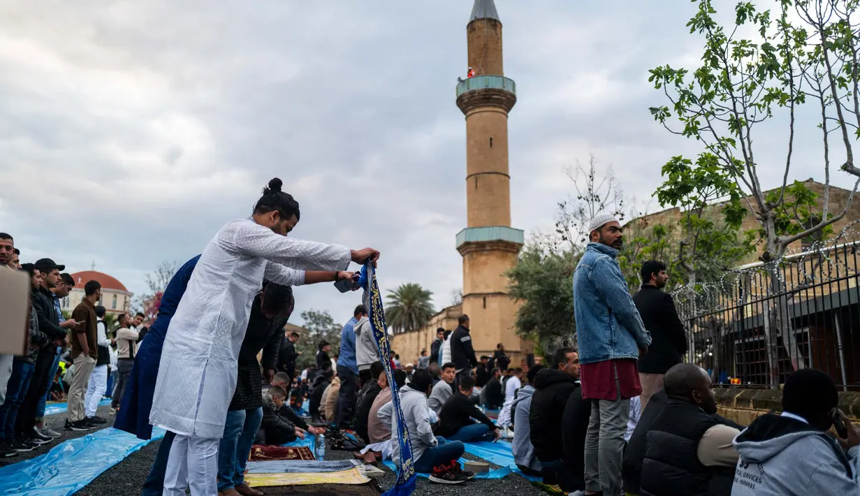 Umat Muslim tiba untuk melaksanakan salat subuh untuk memulai perayaan Idul Fitri di luar sebuah masjid di Nikosia pada 10 April 2024. (Jewel SAMAD/AFP)